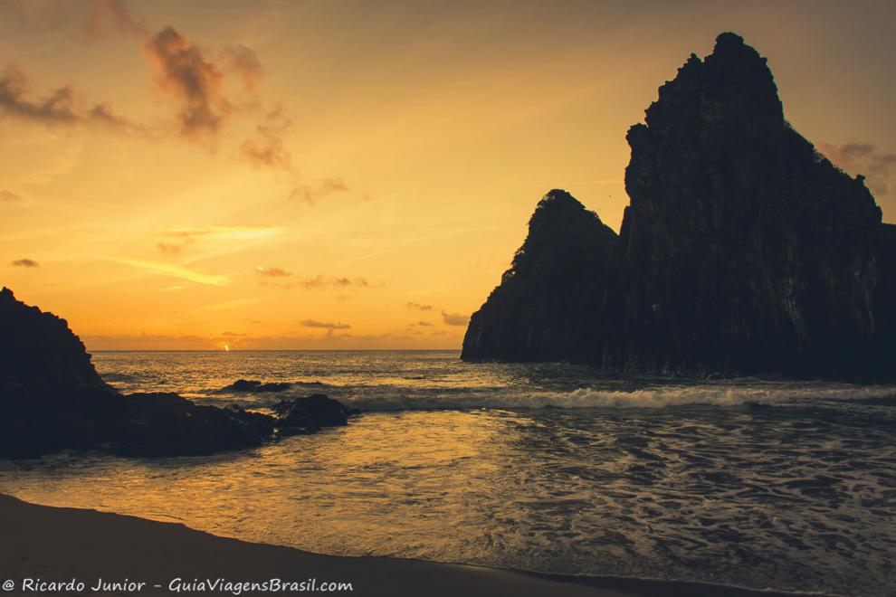 Imagem de um dia ja sem sol mas de um laranja lindo e o Morro Dois Irmãos.